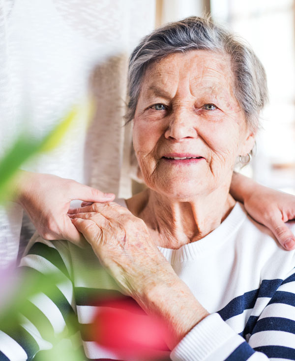 senior woman holding the hand of a caregiver