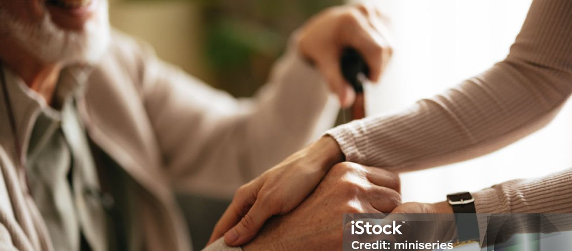 caregiver grabbing senior man's hand