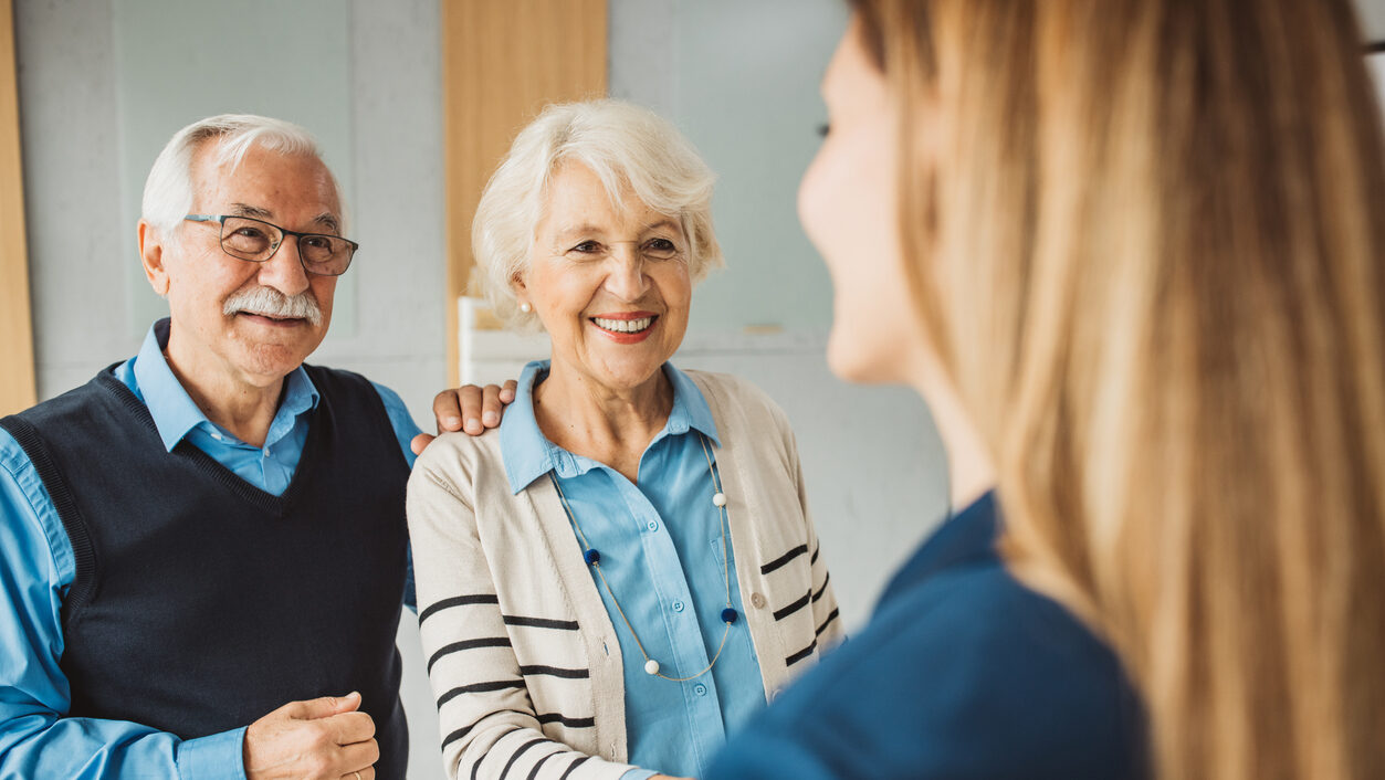 Senior couple talking with female financial or real estate advisor at her office.