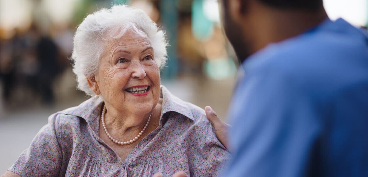 Caregiver talking with his client at a cafe, having nice time together.
