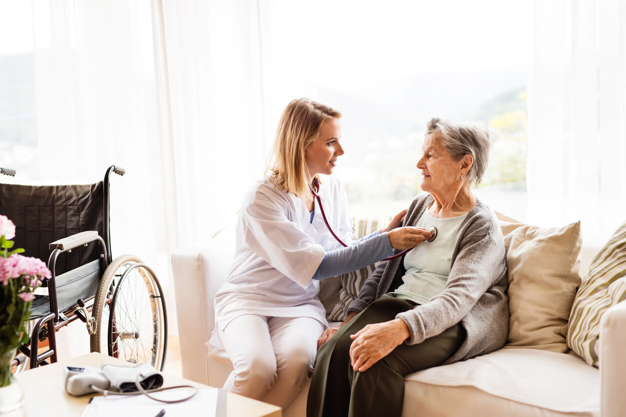Health visitor and a senior woman during home visit. A nurse or a doctor examining a woman.